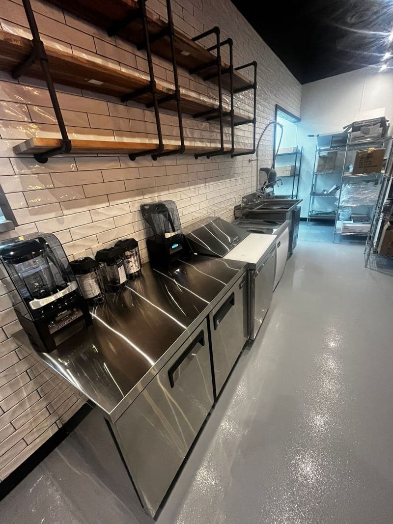 Cafe counter with stainless steel units and a tiled splashback